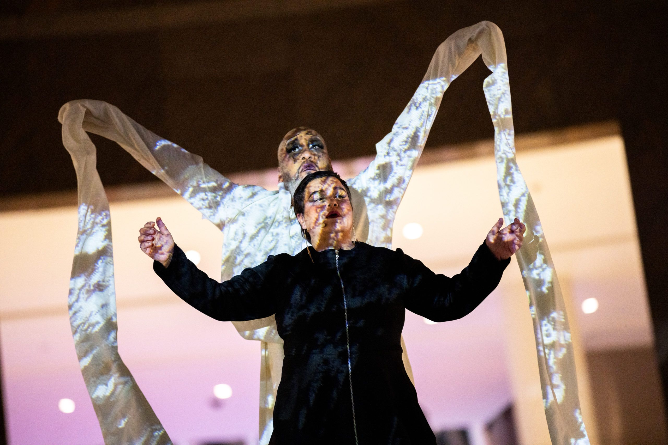 A black and white photo of a young person walking in through a graffitied empty alley.